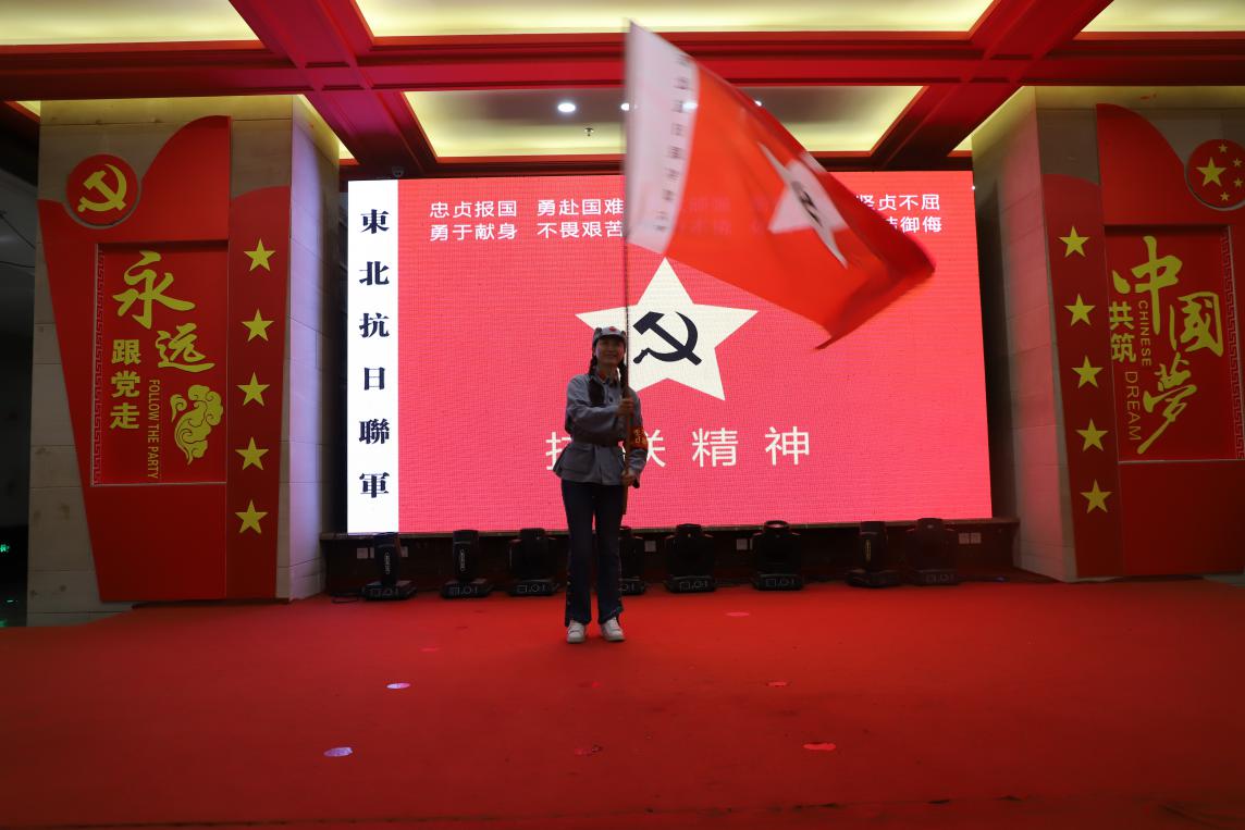 电气学院党委书记单鹂娜同志接过东北抗联军旗电气学院院长刘骥同志在